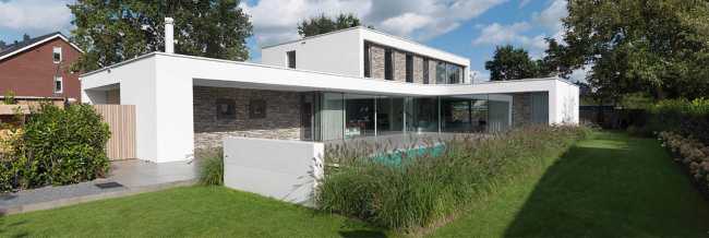 Villa a forma di L in intonaco bianco e pietra