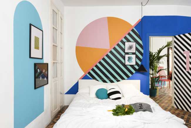 Camera da letto con geometrie colorate sulle pareti