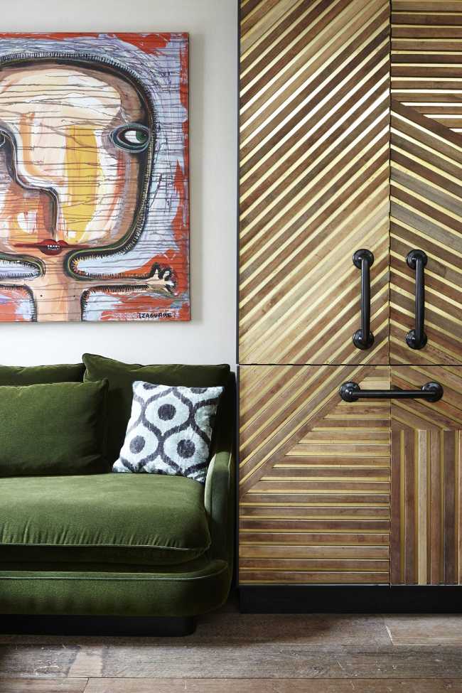 Sofá cuadrado verde y armario de madera.