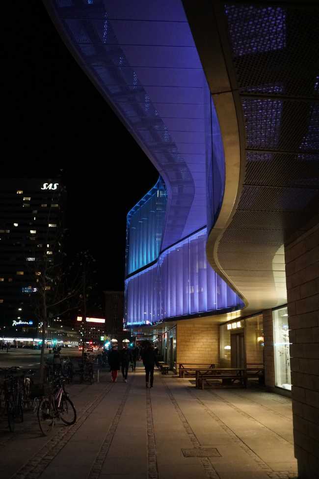 volumes ondulés se croisant éclairés par des lumières colorées de nuit