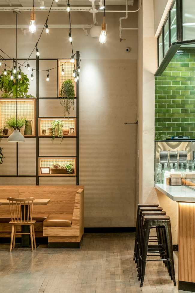White brick wall, hanging lights and wooden furniture