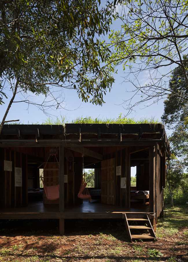 Edificio de madera oscura en una planta de entrada con escaleras