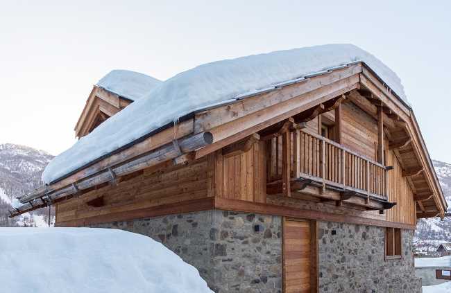 Chalet legno e pietra innevato
