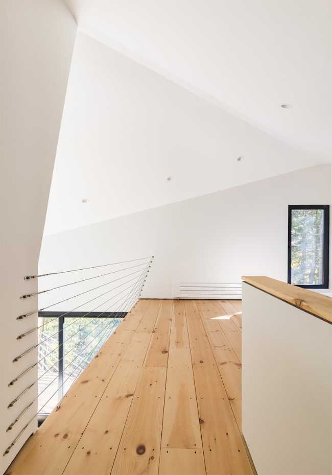 Spazio a doppia altezza in legno ed intonaco bianco