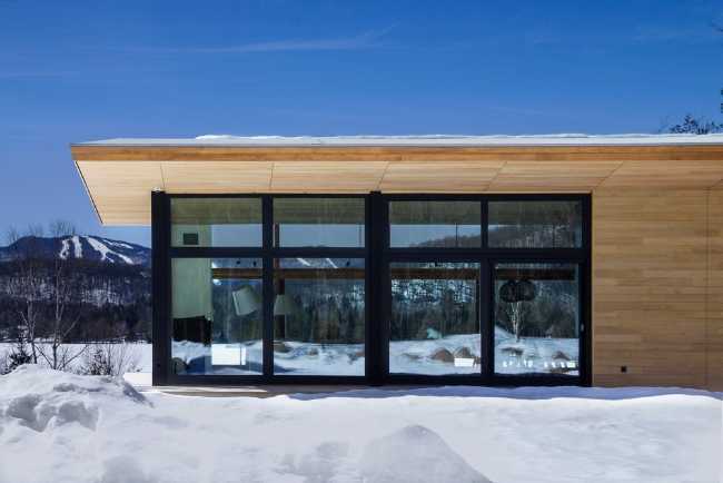 Vetrata con alluminio nero e tetto in legno