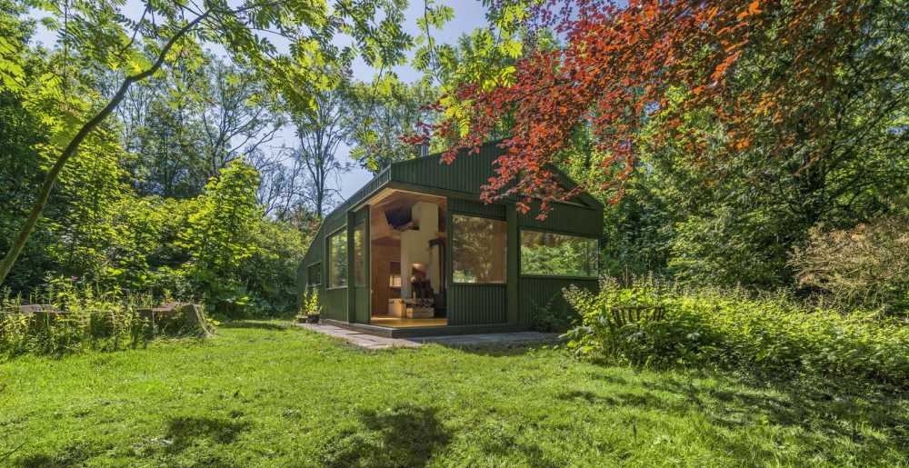 Baita in legno verde tra gli alberi