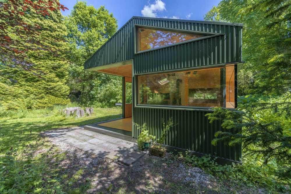 Baita in legno verde tra gli alberi