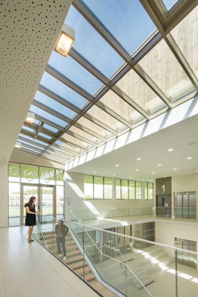 Double height sports center interior with glass balustrade