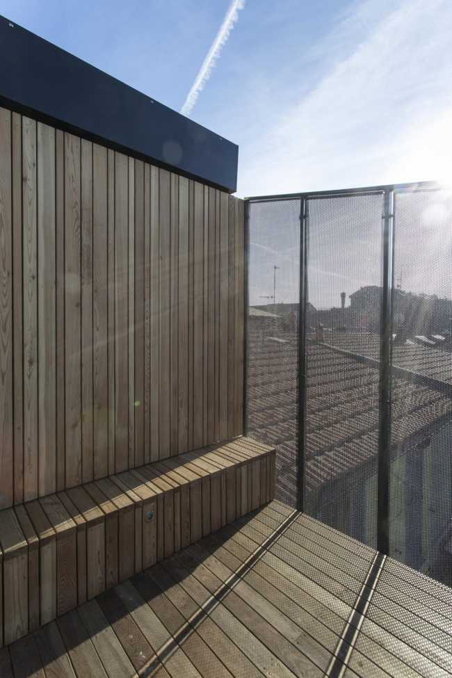 Wooden terrace with black metal balustrade