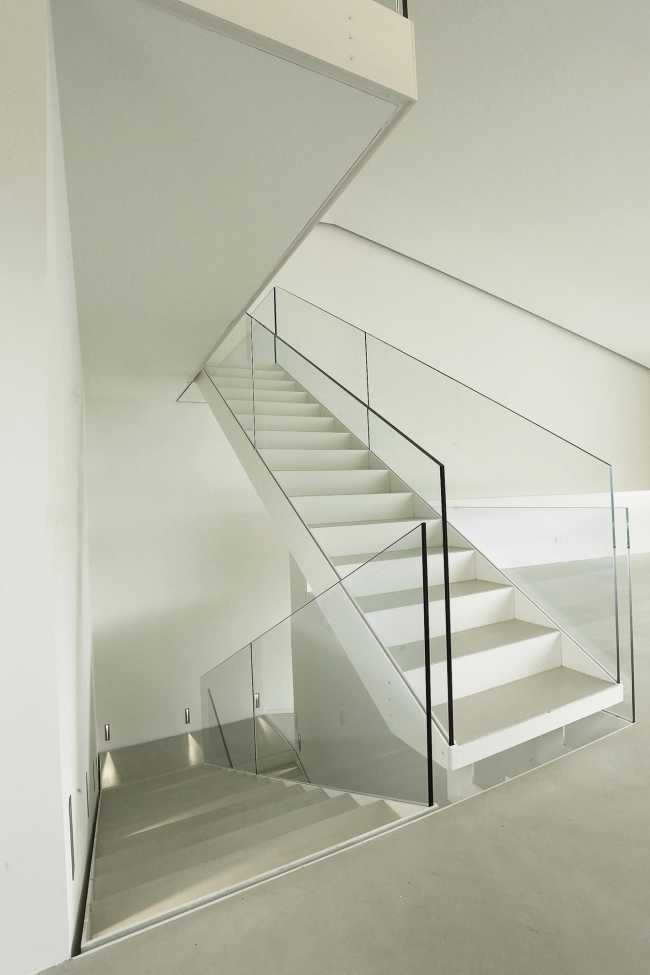 Villa interior with white staircase and glass balustrade