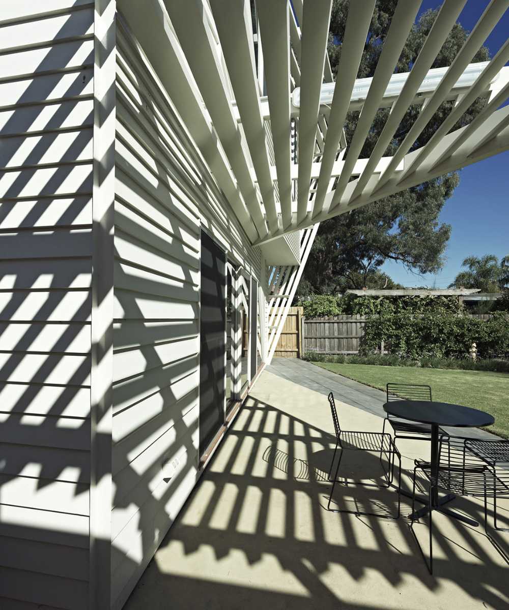 Vivienda de madera con juego de luces y sombras en la terraza