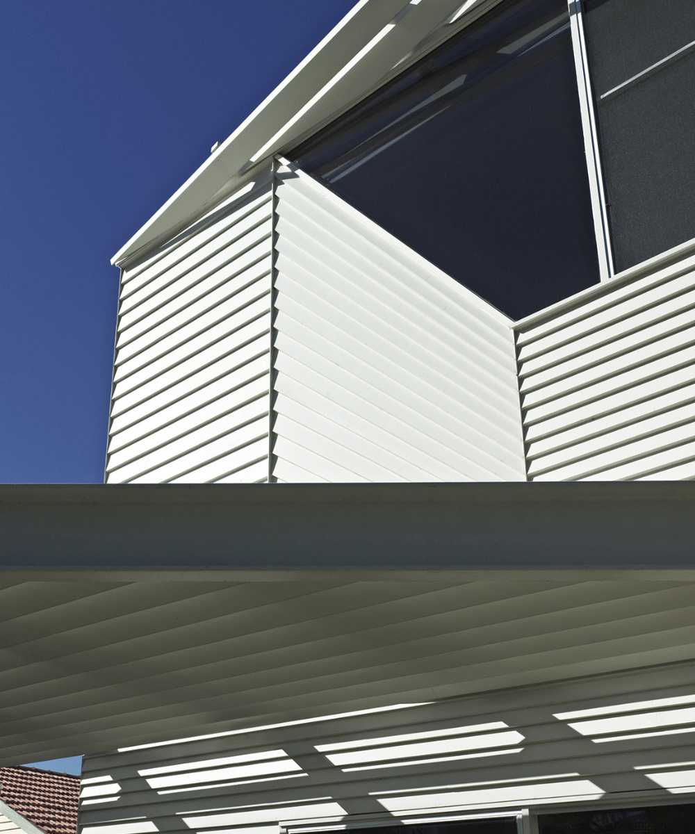 Vivienda de madera con juego de luces y sombras en la terraza