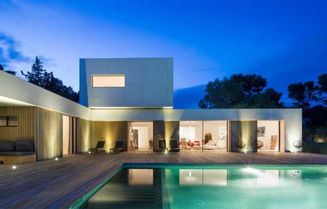 Villa a L con piscina illuminata di notte