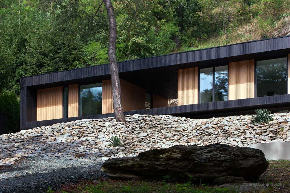 Dark and light wooden villa on the rock