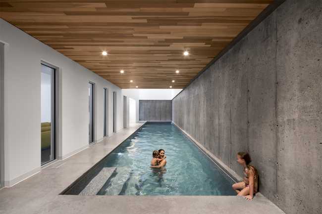 Piscina cubierta con techo de madera e iluminación
