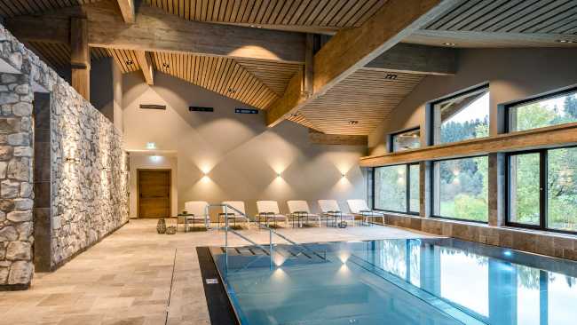 Area relax con piscina in legno e pietra per un resort di lusso