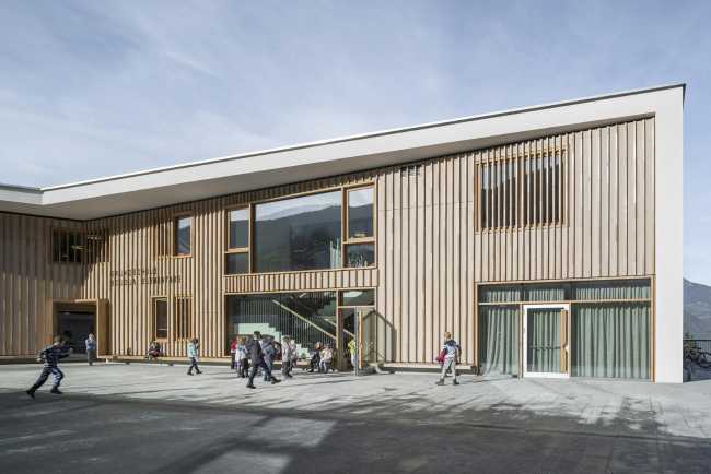 School with a wooden facade and a green roof