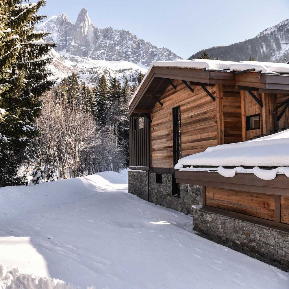 Cabaña de madera con árboles nevados