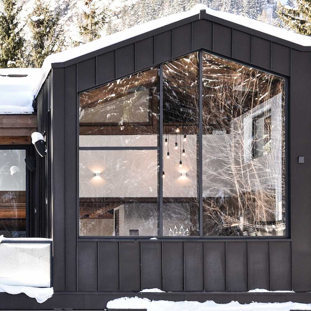 Cabaña de madera con árboles nevados