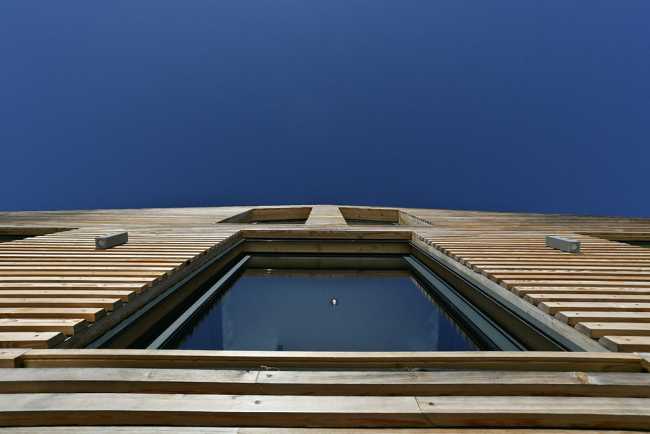 Dettaglio facciata con doghe di legno e cielo