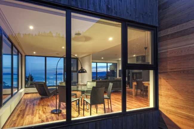 Vetrata di un'abitazione in legno dagli interni contemporanei