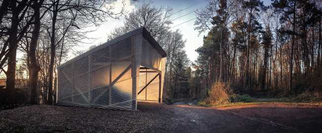 Laboratory among the trees with wooden structure and transparent walls fiberglass corrugated steel