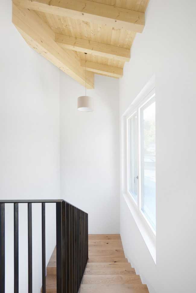 Interni chiari di una residenza in legno con balaustra scura