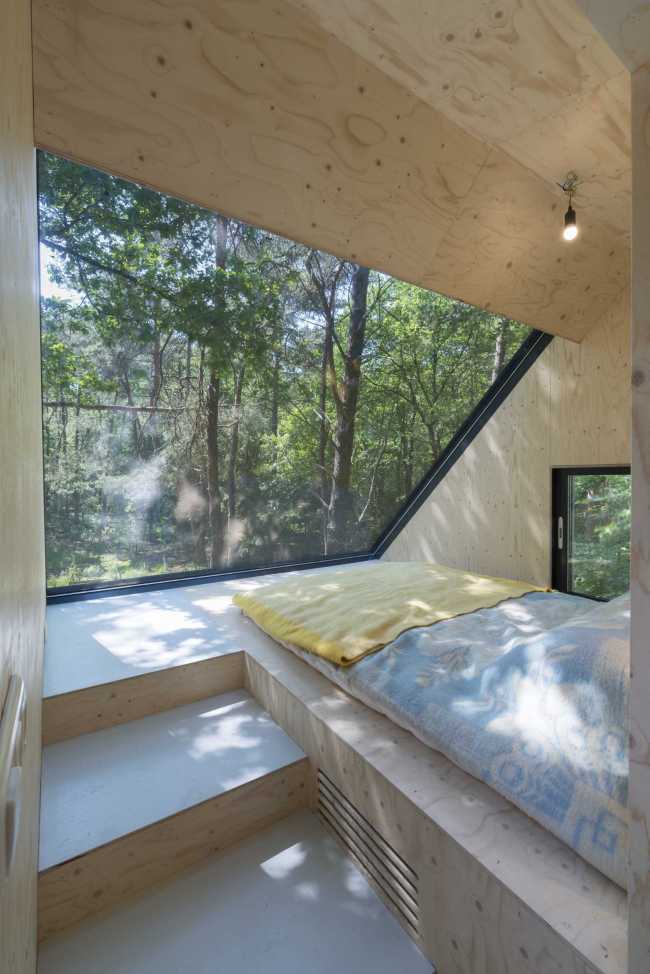 Dormitorio con ventana sobre la naturaleza