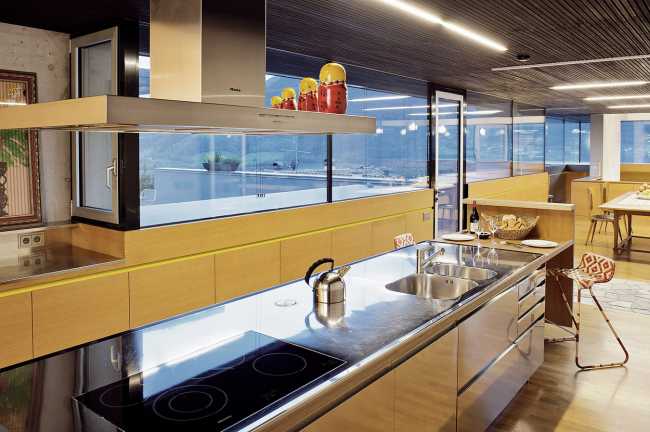 Cucina in acciaio in contrasto con il legno