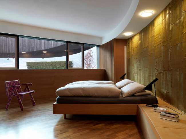 Camera da letto con parete curvilinea e vetrata