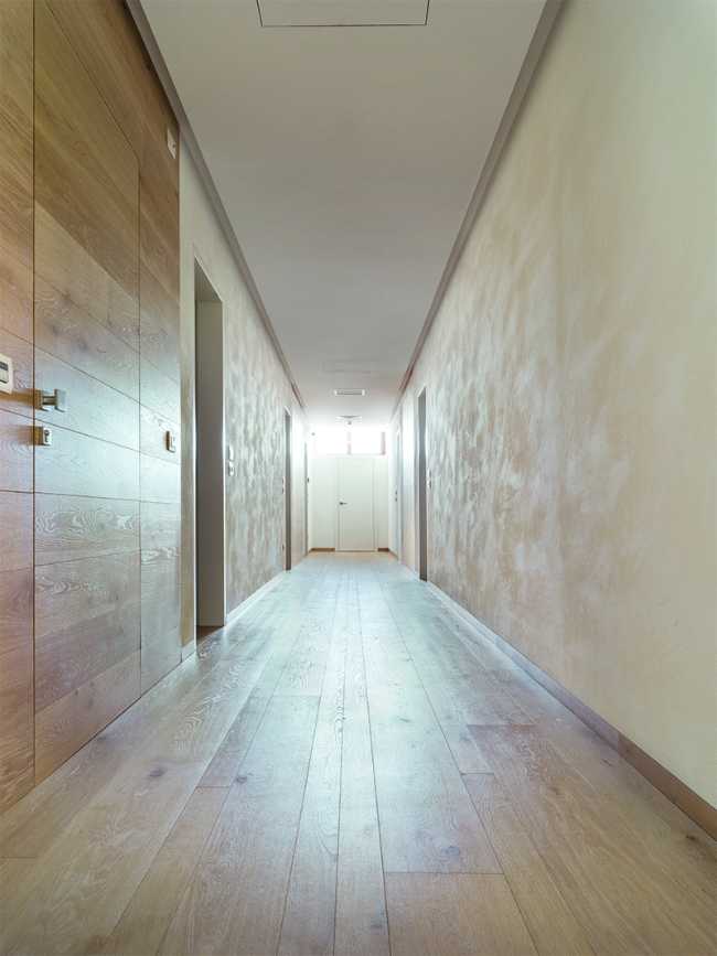 Corridoio dal design essenziale e porte filo muro