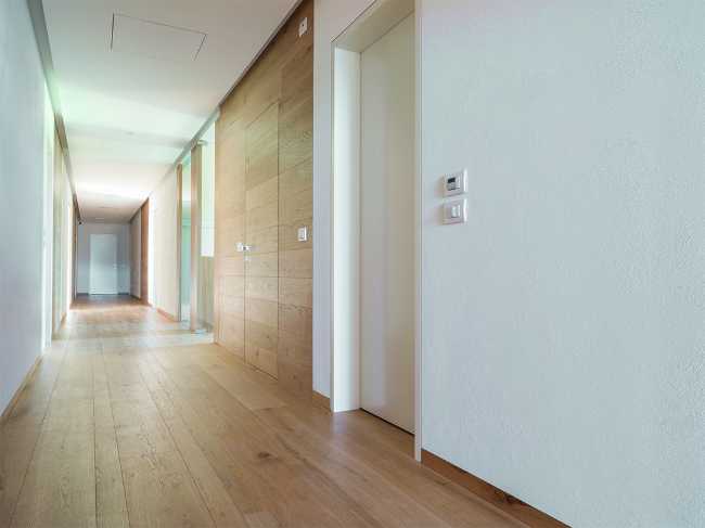 Corridoio dal design minimal in legno e bianco