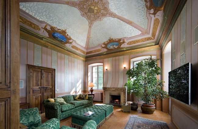 Casa storica con divano verde e dipinti sulle pareti