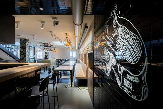 Interno ristorante con parete nera e disegni bianchi