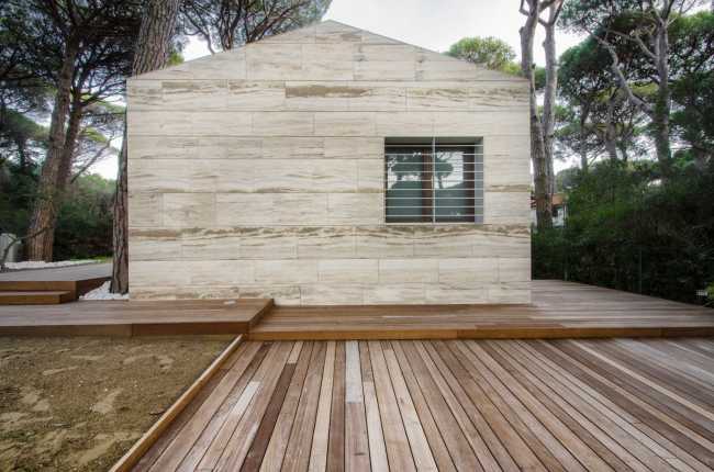 residencia cubierta en travertino con formas tradicionales