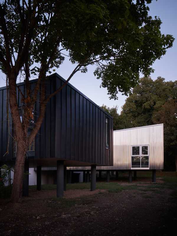 Scuola elementare con facciata in metallo tra gli alberi