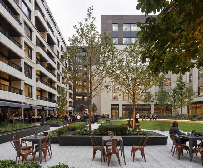 Outdoor space between residential buildings with bar and tables