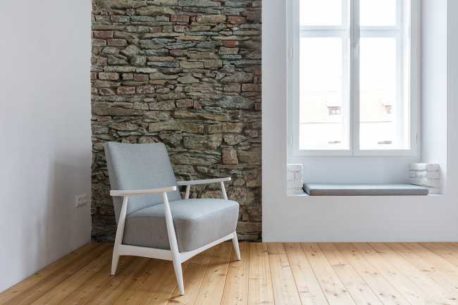 Esquina con pared de piedra y sillón