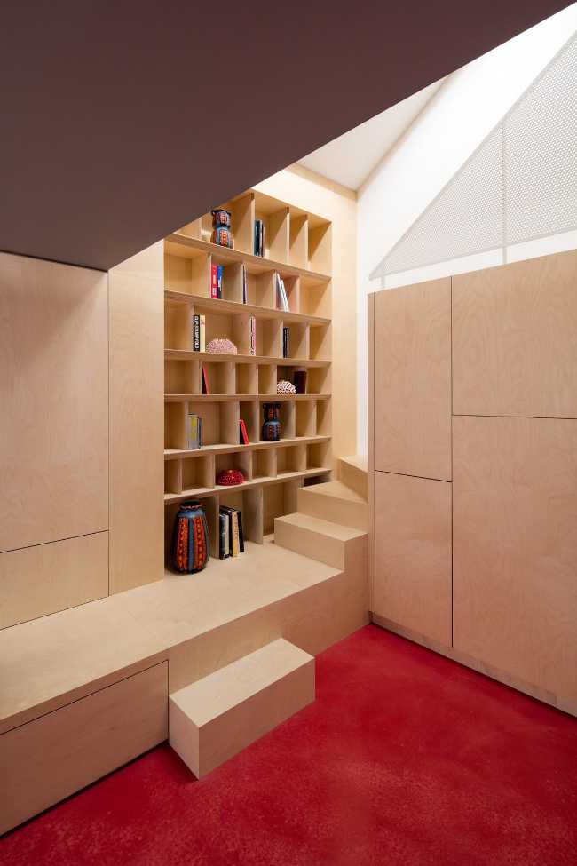 Interior con suelo rojo y muebles en las paredes de madera