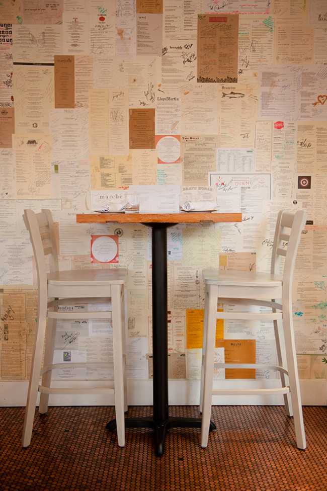 A restaurant table with a wall full of newspapers