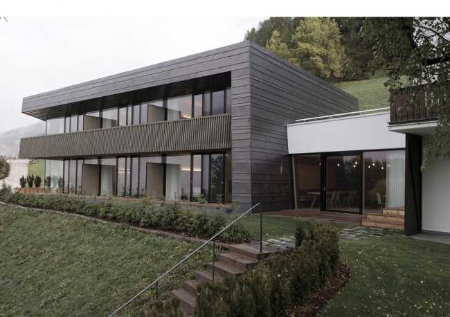 Villa oscura de formas contemporáneas