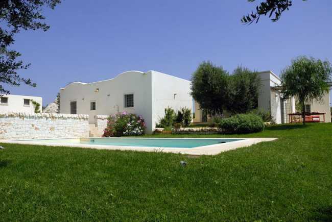 Prato verde con piscina e architettura dell'italia meridionale