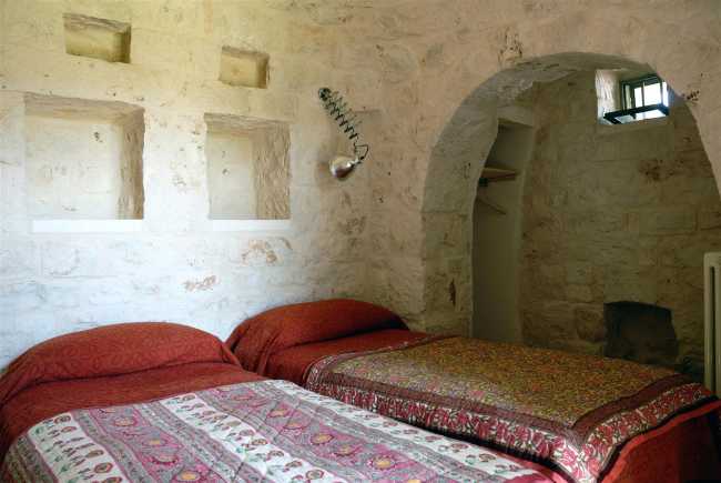 Camera da letto tra pareti in pietra