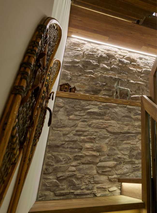 Scala in legno e rivestimento in pietra per un resort di lusso