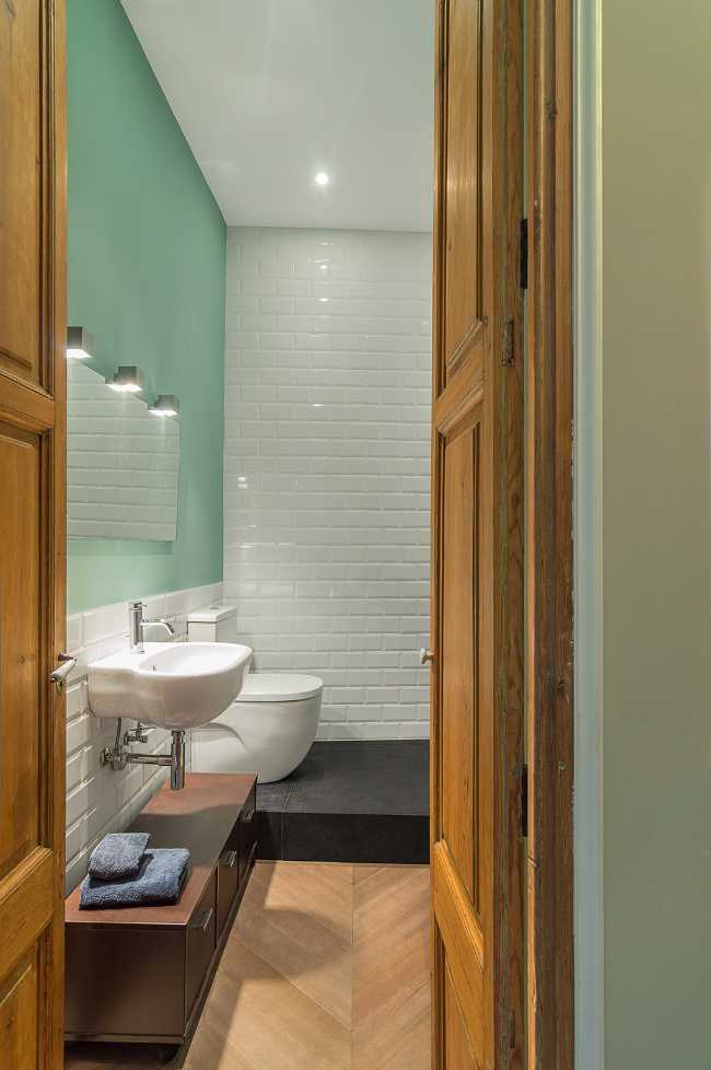 baño de parquet y azulejos blancos