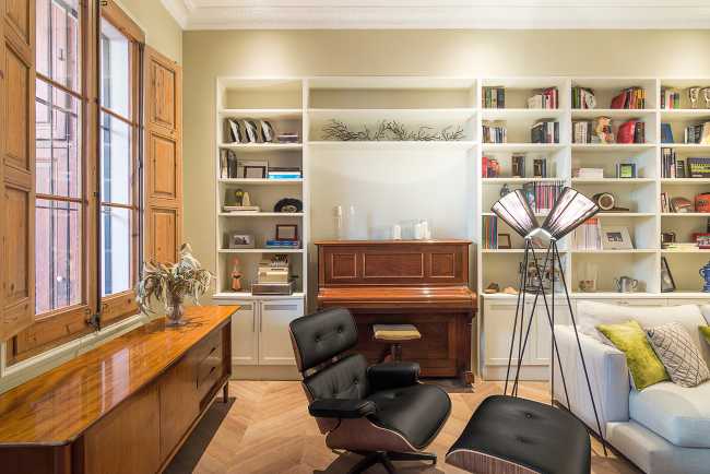 salón con sillones de piano y librería