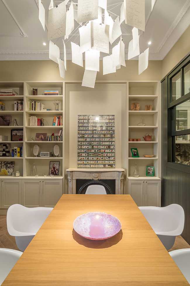 salón con mesa de madera y sillas blancas