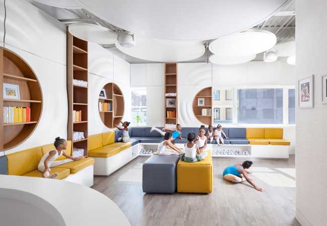 dance school with white interiors and grey and yellow sofas