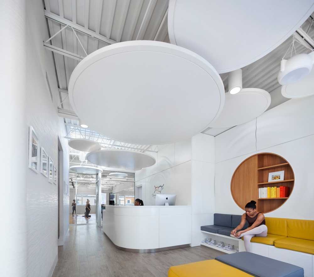 dance school with white interiors and grey and yellow sofas