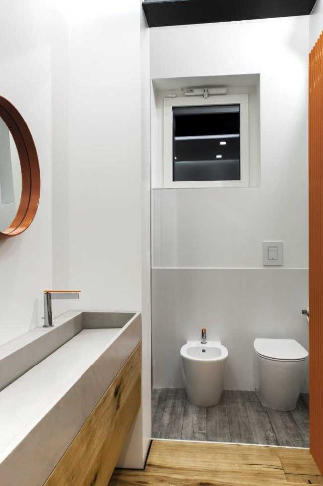 Bagno con parquet e pareti bianche